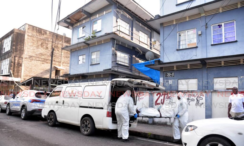 The body fo the unidentified shooting victim is removed at Nelson Street, Port of Spain on Tuesday. PHOTO BY ANISTO ALVES - 