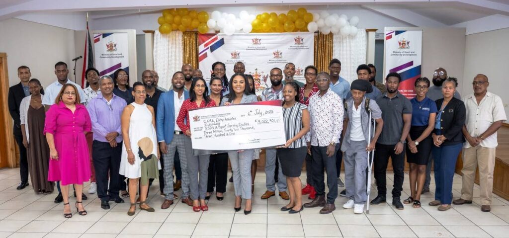 Minister of Sport and Community Development Shamfa Cudjoe, middle, with national sporting body representatives, athletes and community group representatives at a hand over cheque ceremony recently. - courtesy Ministry of Sport and Community Development