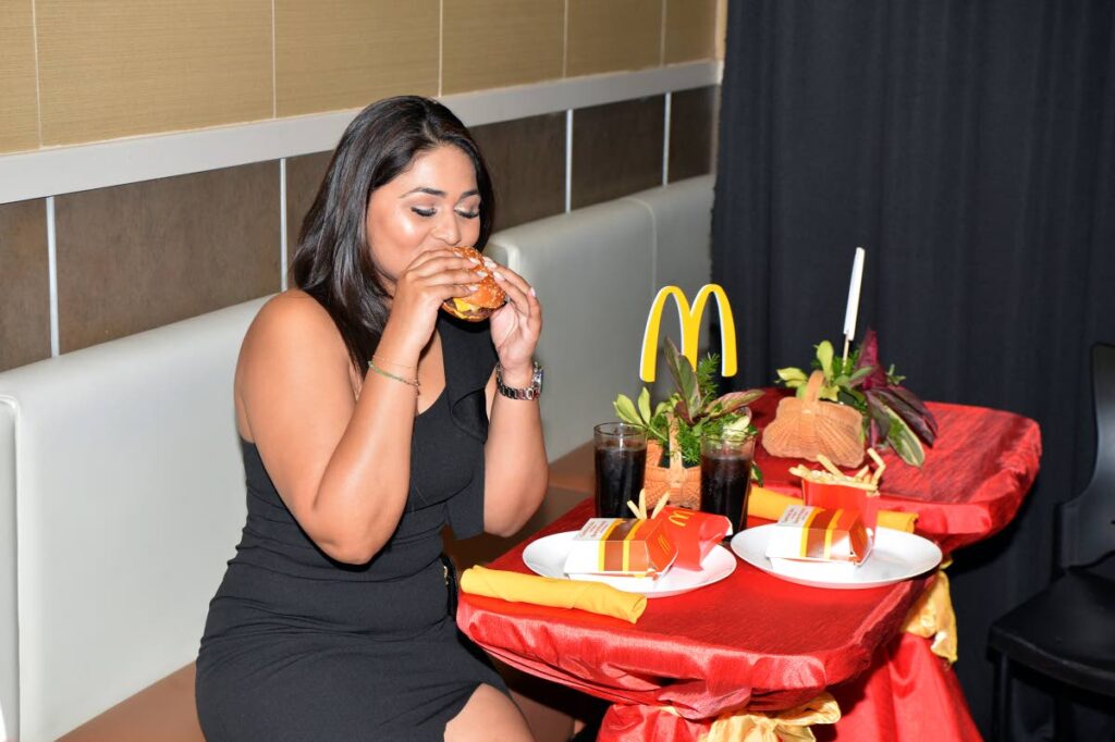 Anastasia Mootoo, content creator and brand ambassador for McDonald’s Trinidad bites into the newly evovled tasting burger.