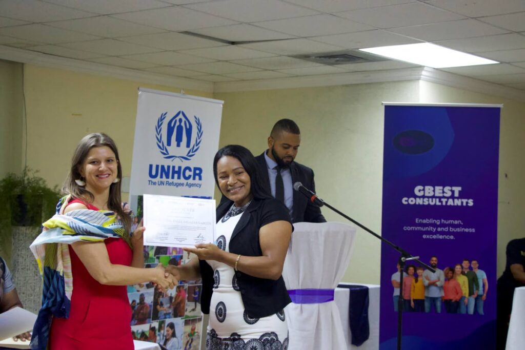 Barbora Masinova of the Programme Unit at UNHCR TT's office presenting certificate to a newly-trained entrepreneur. - 