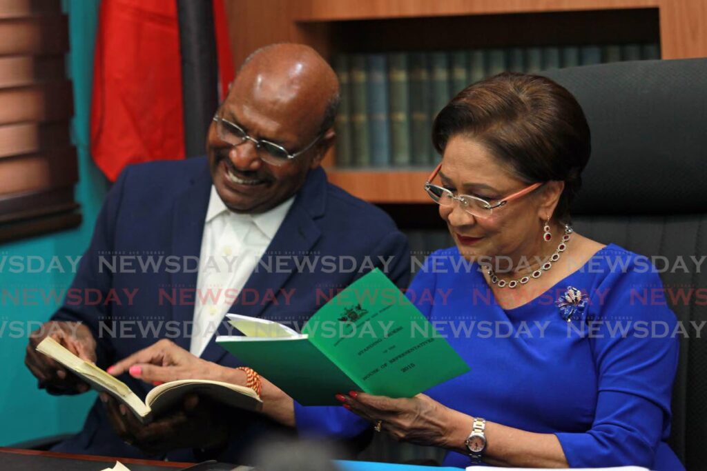 Opposition leader and leader of the UNC, Kamla Persad Bissessar looks at the standing orders with senator Wade Mark during a news conference held at her Siparia constituency office, Penal, on Friday. - Photo by Lincoln Holder