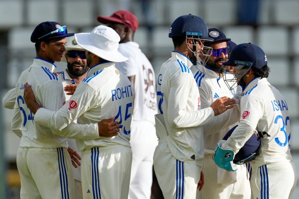 JOB DONE LADS: India players congratulate each other on taking the final wicket to consign the inept West Indies to an inns and 141 runs defeat on day three of the first Test on Friday in Windsor Park, Roseau, Dominica. AP PHOTO   - Ricardo Mazalan