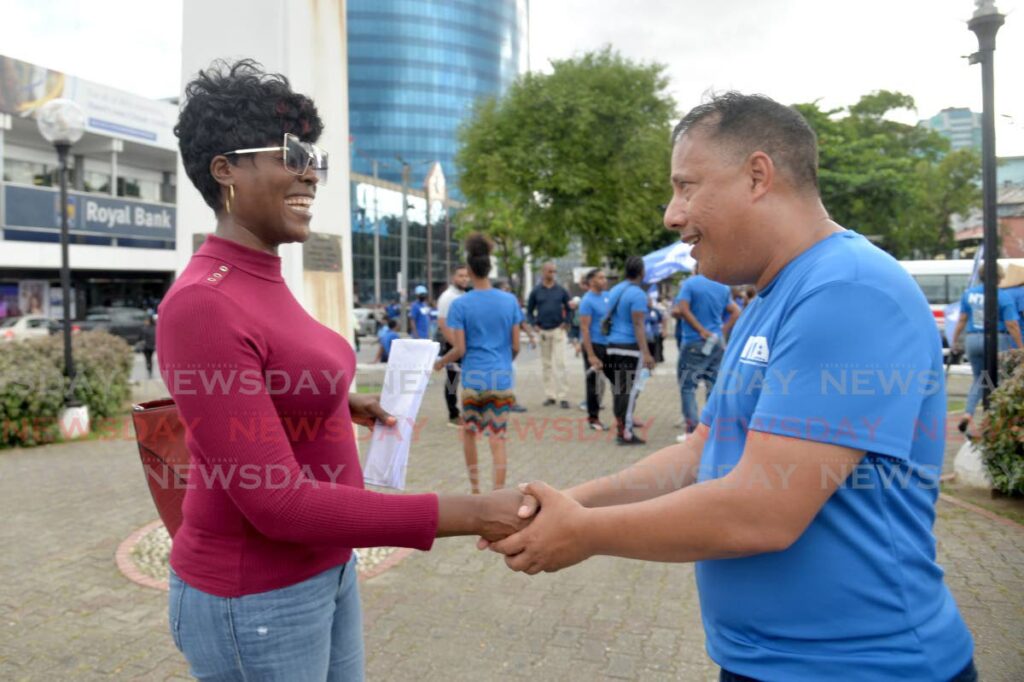 Gary Griffith, political leader of the National Transformation Alliance (NTA), left, speaks with a member of the public during a party event on the Brian Lara Promenade in Port of Spain on Friday.  -                                 