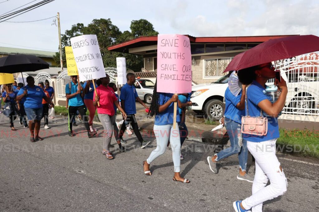 Citizens carry anti-crime signs in a march along Oropouche Road, Fyzabad on Saturday. - Jeff K Mayers