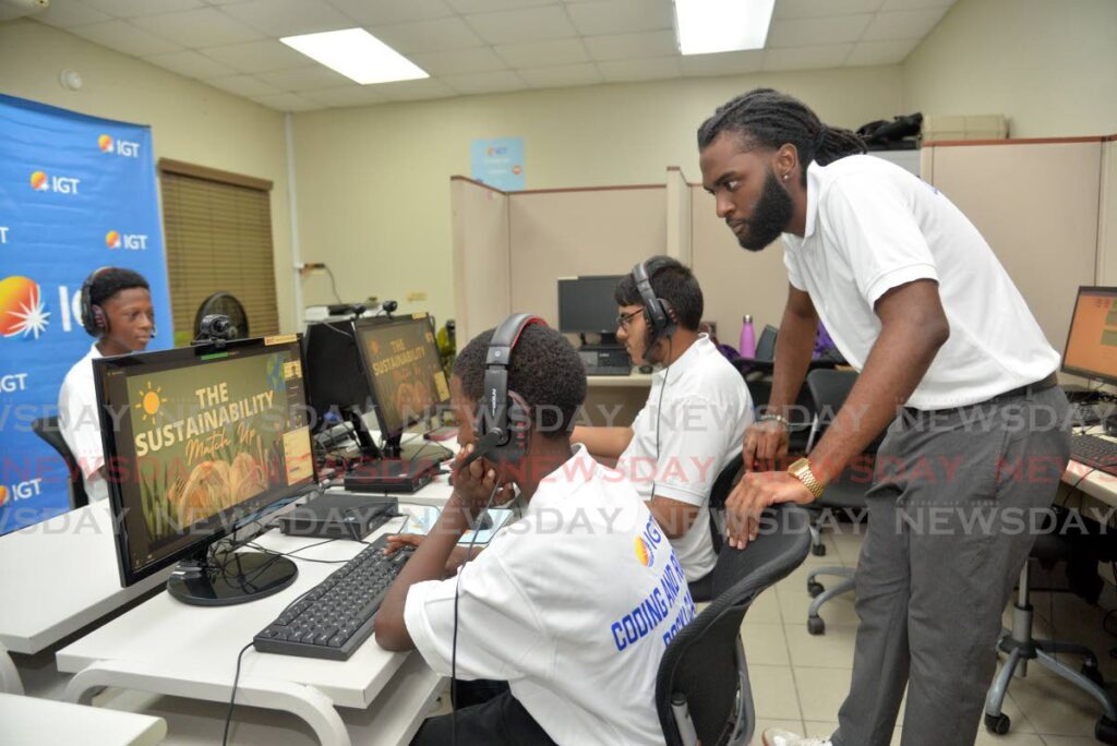 Camp supervisor Isaiah Alexander with participants in the IGT Coding and Robotics Rock! Camp at the Cotton Tree Foundation, Spanish Acres, Ariapita Road, St Ann's, on Monday.  - Anisto Alves