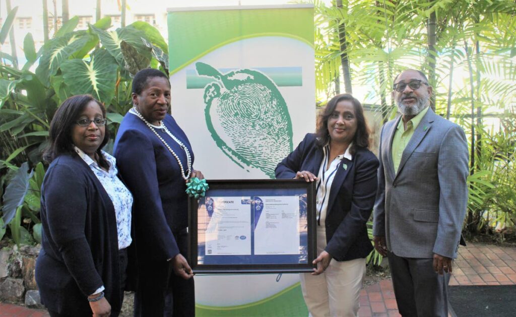 Pennelope Beckles , Minister of Planning and Development and chairman of the EMA, Nadra Nathai-Gyan proudly hold the EMA’s ISO 9001:2015 certification.  Looking on are Hayden Romano - Managing Director of the EMA (far right) and Frances Mitchell-Wanliss – Manager - Quality/ISO & HSE (far left).  - Planning Ministry 