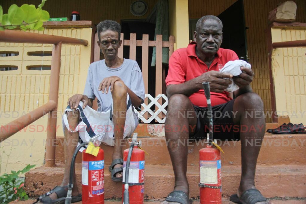 VAIN RESCUE ATTEMPTS: David Cornwall and his neighbour Stanley Dick, right, with the fire extinguishers they used to try to rescue their neighbour Michael 