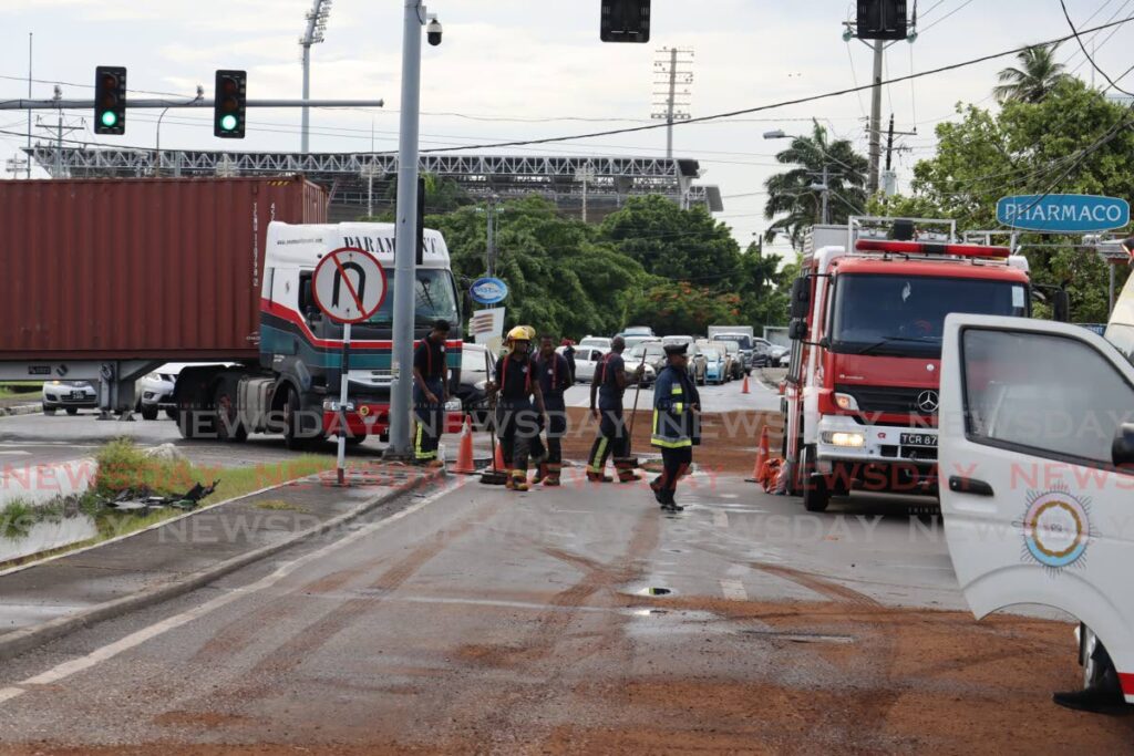 Firefighters and other emergency services respond to an oil spill on the east-bound lane of Wrightson Road between Ana and Luis streets in Port of Spain, on Wednesday afternoon. - Photo by Roger Jacob