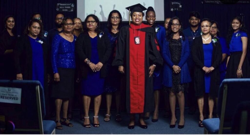 Dr Karlene Sookoo (centre) standing with her 2019 graduating class at Princes Town Open Bible church. - 