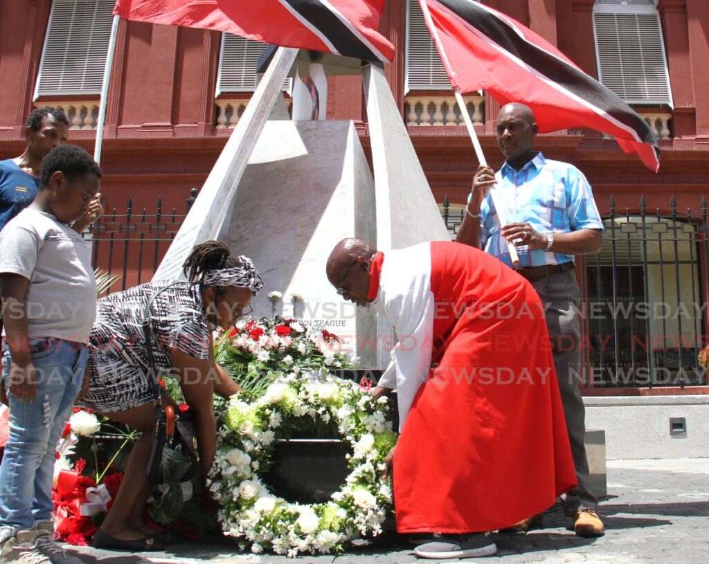 REMEMBERING 1990: Afeisha Caballero, daughter of parliamentary clerk Lorraine Caballero, and activist Wendell Eversley lay a wreath at the cenotaph in memory of those who died during the July 27, 1990 attempted coup at the Red House on Abercromby Street, Port of Spain on Thursday. Lorraine Caballero was killed in the 1990 uprising. - Ayanna Kinsale