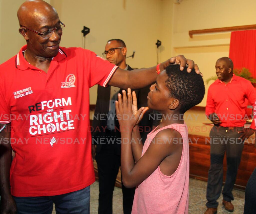 Jamarie John, 12, chats with Prime Minister Dr Keith Rowley following Conservations with the Prime Minister at Palo Seco Government Primary School on Friday night. - Lincoln Holder