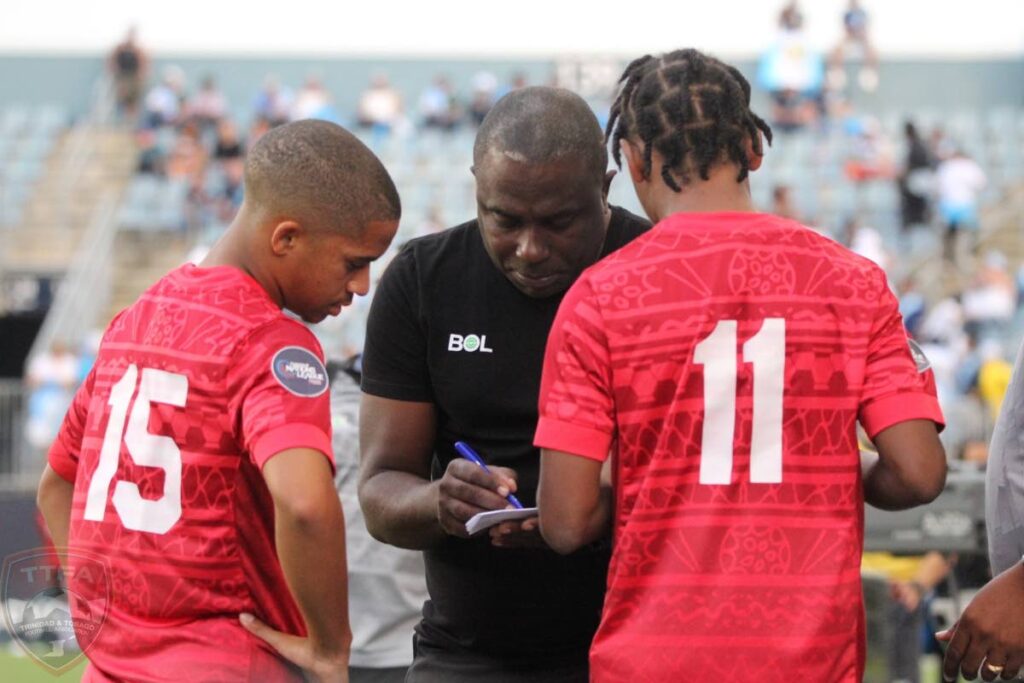 TT head coach Angus Eve, centre, talks to TT players Kaile Auvray, left, and Real Gill before sending them on as substitutes in a friendly vs Guatemala at Subaru Park, Philadelphia on June 12. - TTFA Media