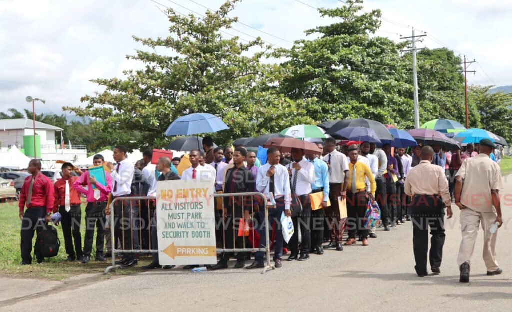 Scores of young men wait to enter the TT Prisons Sports Club, Arouca, to be interviewed for recruitment in the prisons service on July 25. - Angelo Marcelle