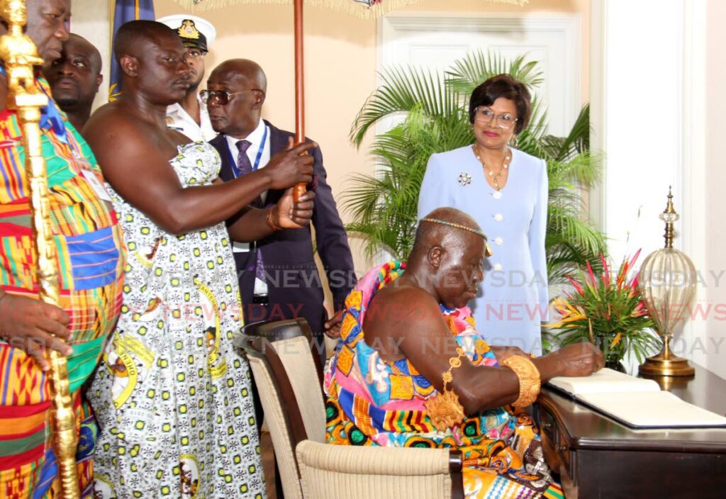 President Christine Kangaloo looks on while the Ashantene King Otumfuo Osei Tutu II of Ghana signs the guest book during a visit to the President's House, St Ann's on Monday. PHOTO BY AYANNA KINSALE - 