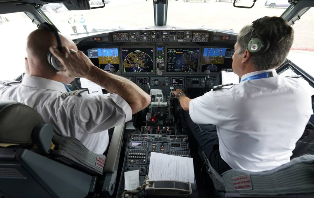 American Airlines pilots conduct a pre-flight check. AP Photo - 