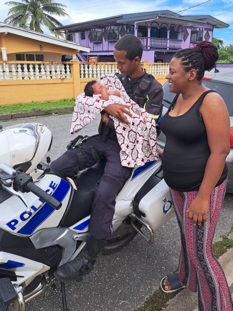 SUPER GRATEFUL: PC Darion Thomas, of the Sangre Grande Police Station, Traffic Section, Eastern Division, holds beautiful, healthy, nine lbs baby girl, Charleigh, during a welfare visit.
Looking on is Charleigh's mother, WPC Cherrelle Thom. - TTPS 