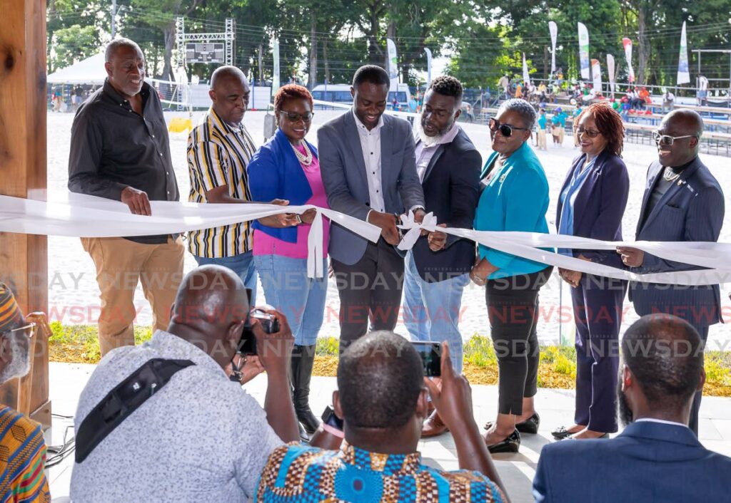 OPENED: THA Chief Secretary Farley Augustine, centre, cuts the ribbon to officiall open the Courland Beach Sport Arena in Tobago on Thursday. The facility will host beach volleyball games in the Commonwealth Youth Games which begins today. PHOTO BY DAVID REID - David Reid