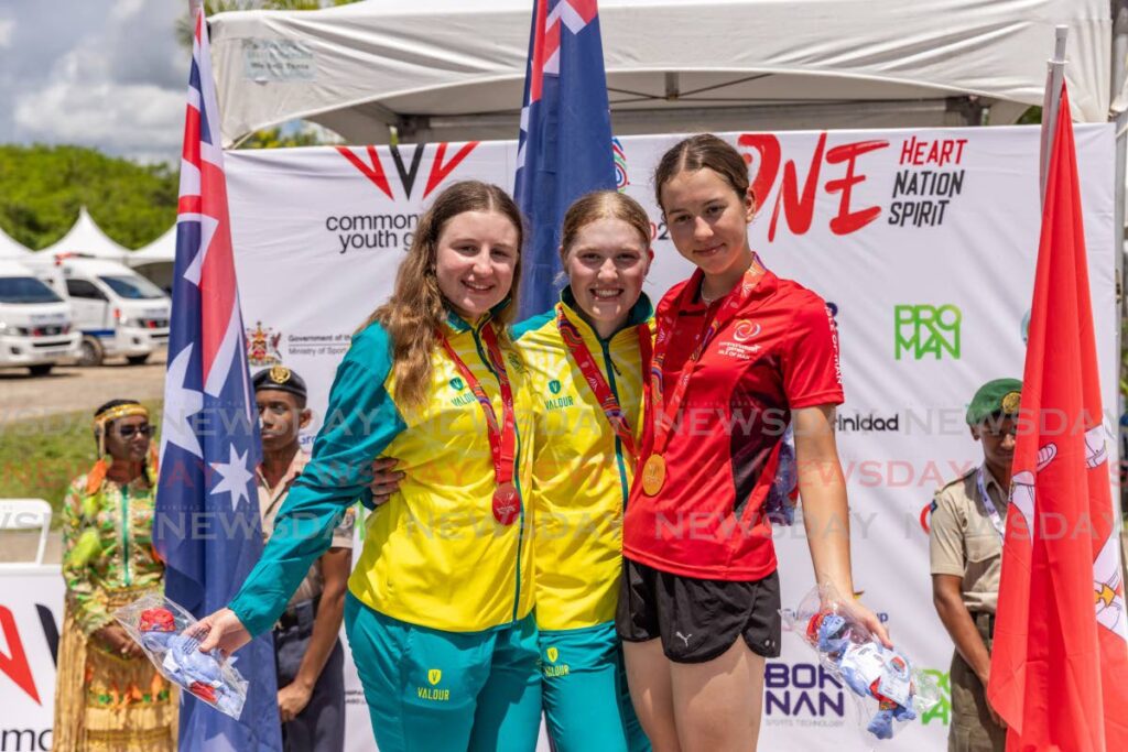 (l-R) Australia’s Keira Will (2nd place), gold medallist Lauren Emily Bates and Isle of Man’s Ruby Oakes (third place) celebrate after competing in the women’s cycling time trial, on Saturday, during the 2023 Commonwealth Youth Games, at the Brian Lara Cricket Academy, Tarouba.  - Jeff K. Mayers