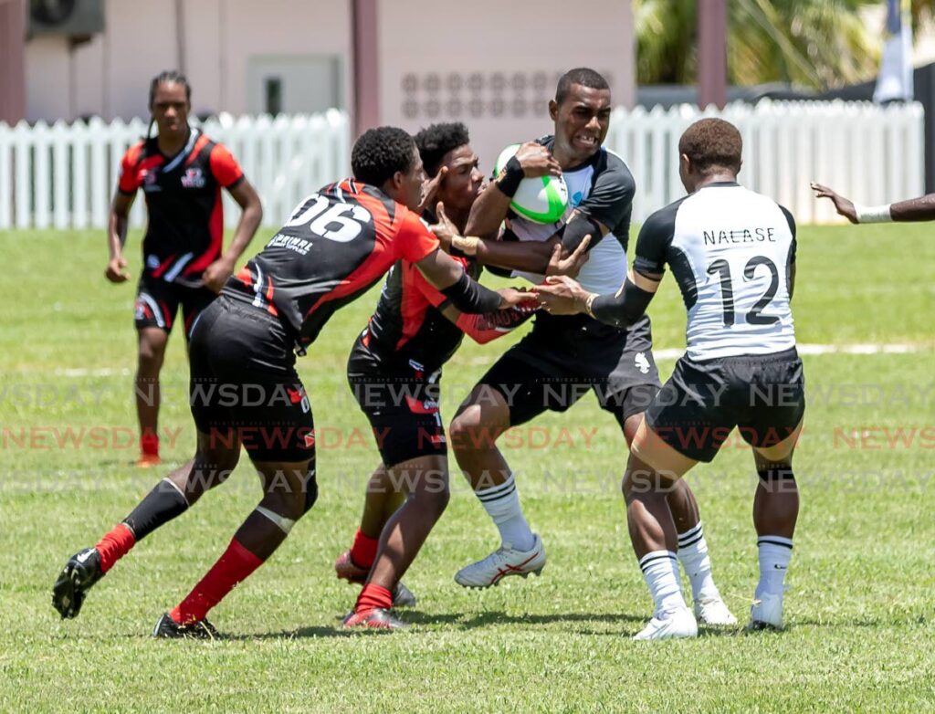 Fiji, right, and TT players battle for the ball in a men's rugby match at the Commonwealth Youth Games, Shaw Park Recreation Grounds, Tobago, Sunday. - David Reid