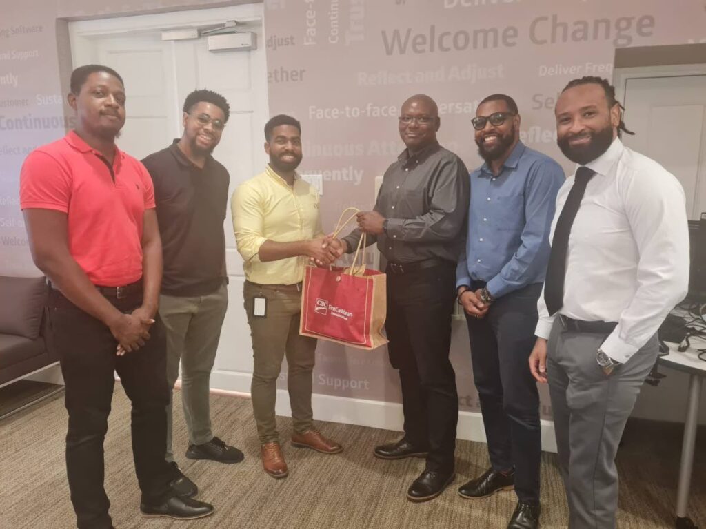 First prize winners, Ctrl-Shift-Create, represented by Steven Jemmott (right); Christopher Millar and Kadeem Austin (missing are: David Callender, Jesse Emamalie, and Irvin Reyes) receiving their prize from Allan Mercer, director of retail credit and sales and business banking and also a judge of the Hackathon. 
Also sharing the spotlight were some members of the judging panel: Trevor Wood, director of data and innovation and Allan Pinder, application and cloud security manager.
(Photo courtesy CIBC FirstCaribbean) - 