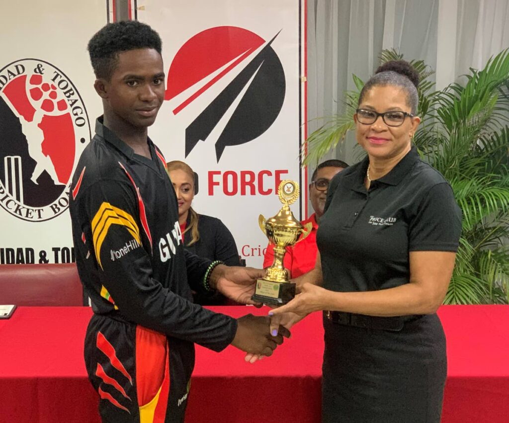 Guyana Under-13 captain Brandon Henry collects one of his awards from Sherma Lewis, Public Relations Officer of The Price Club Supermarket of Chaguanas. - 