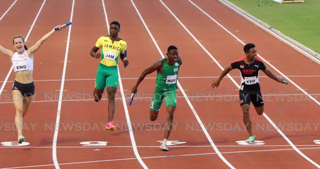 Nigeria's Isreal Sunday Okon, second from right, dips at the line to win the mixed 100m relay ahead of England's Thea Brown, left, and TT's  Jamario Russell, right, at the Commonwealth Youth Games, Hasely Crawford Stadium on Thursday. Finishing fourth was Jamaica's Shaquane Gehvon Gordon.  - Angelo Marcelle