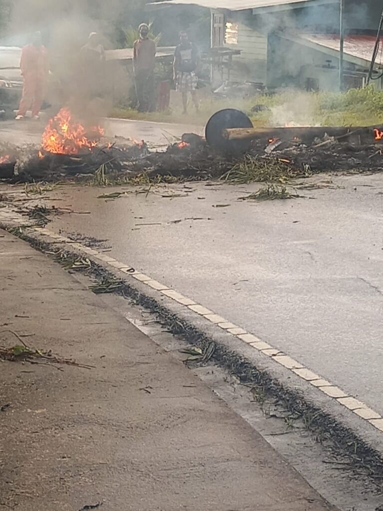 Fire officer extinguished the burning debris during the protest at Rio Claro on Friday.  
