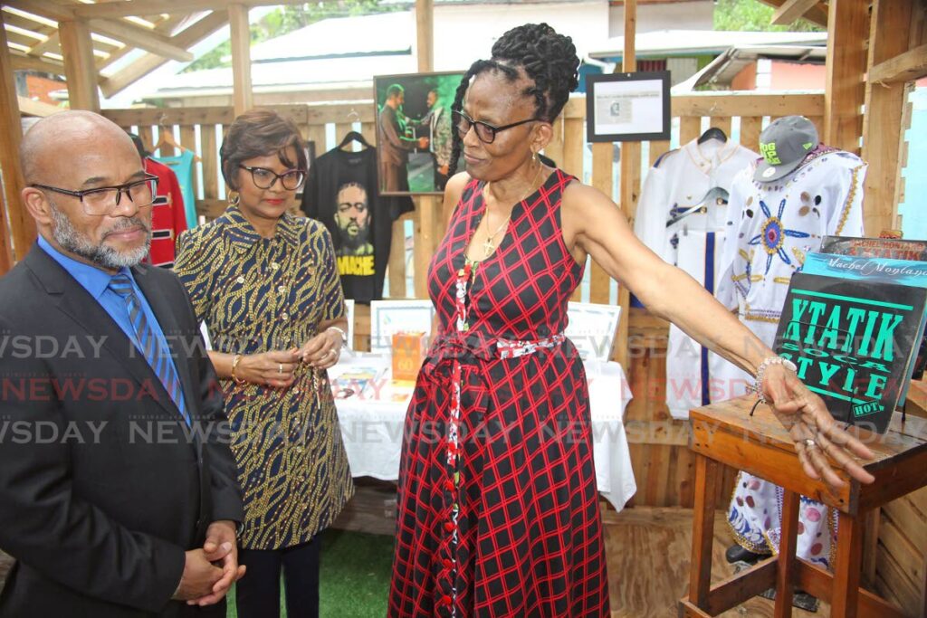 Author Elizabeth Montano, mother of soca star Machel Montano, shows President Christine Kangaloo and her husband Kerwyn Garcia mementos of her son's career during a visit to Siparia Deltones panyard, Siparia on World Steelpan Day. Montano recorded a song The Meeting Place with South African musician Hugh Masekela, before his death, and the steelband  - Lincoln Holder
