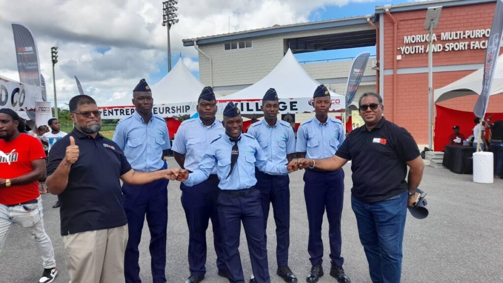 Permanent Secretary in the Ministry of Youth Development and National Service  Farook Hosein, left, and director of the Youth Affairs Division Sean Ramrattan, greet some cadets from the Military-Led Academic Training Programme (MiLAT) at the youth Caravan in Moruga. - 