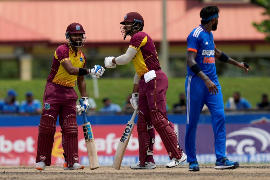 West Indies' Nicholas Pooran, left, knocks gloves with Brandon King during the fifth T20 cricket match against India at Central Broward Regional Park in Lauderhill, Florida, Sunday. - AP