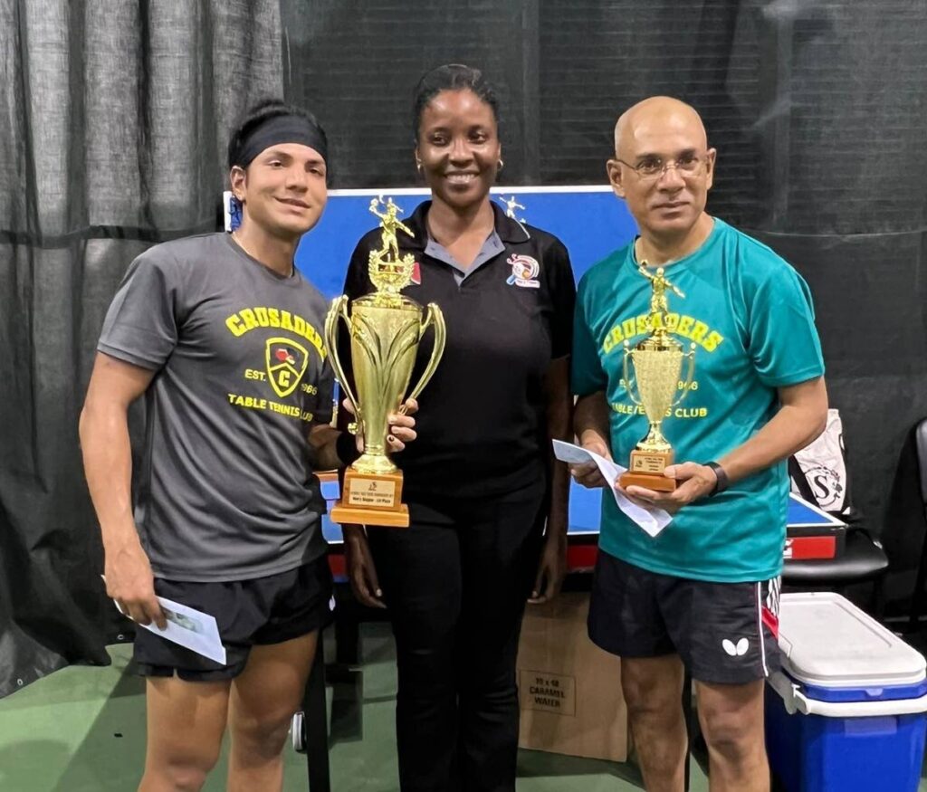TT Table Tennis Association president Shellyanne Wilson, centre, presents the nationals men's singles trophy to Khaleel Asgarali, left, and the veteran singles trophy to his father Nazruddin Asgarali, at the National Racquet Centre, Tacarigua.  - 