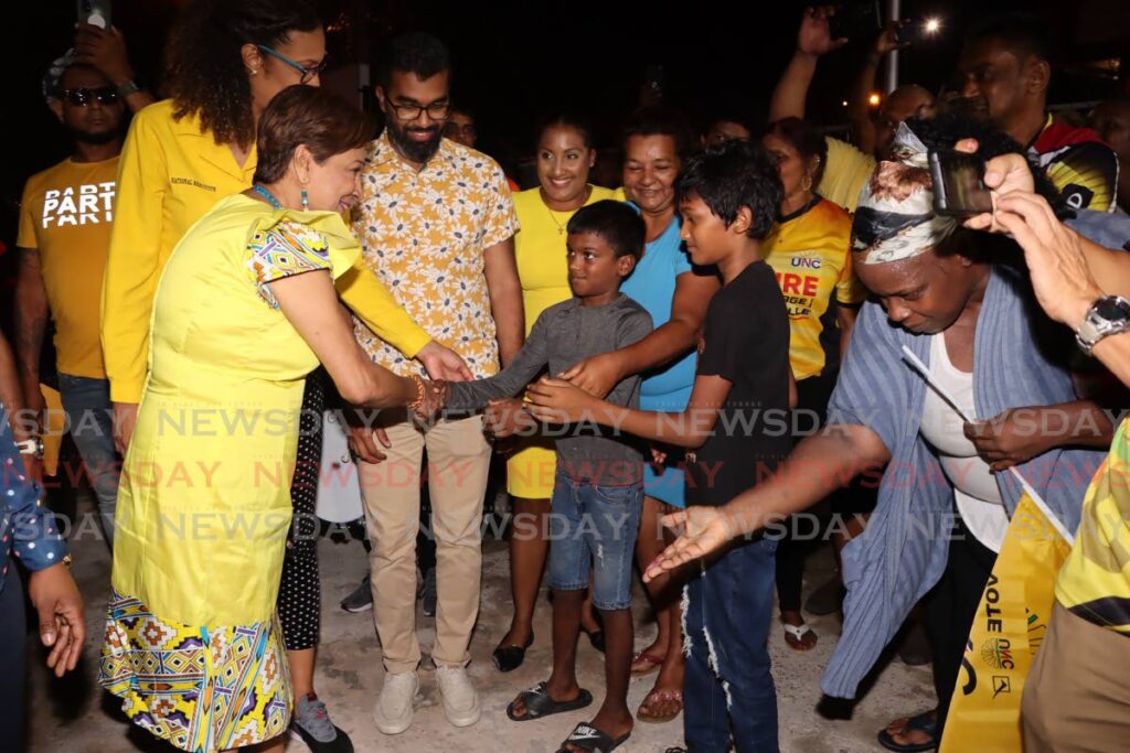 UNC Political Leader Kamla Persad Bissessar greets supporters as she arrives at the party's headquarters in Chaguanas on Monday night.  - ANGELO MARCELLE