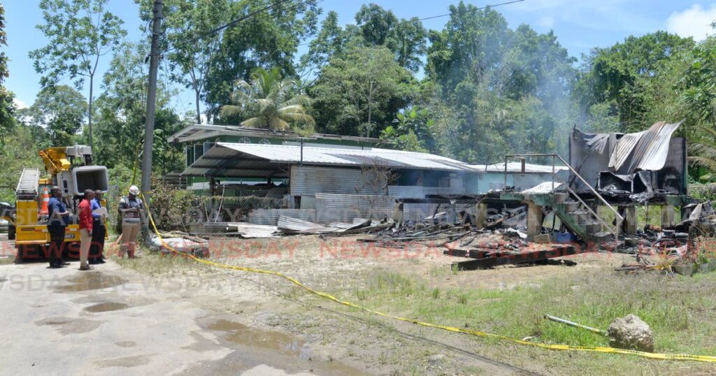 Investigators at the fire that distroyed the home and took the livies of Natasha Nancoo and her two children at Cooblal Trace, Toco Main Road, Sangre Grande on August 17 - Photo by Anisto Alves