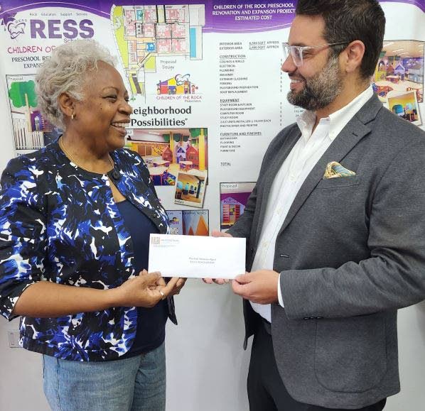 Kate Agard of the Morvant preschool, Children of the Rock, receives a $40,000 donation towards equipping their STEM lab from ANSA McAL Foundation director Nigel Sabga. - Photo courtesy ANSA McAL Foundation