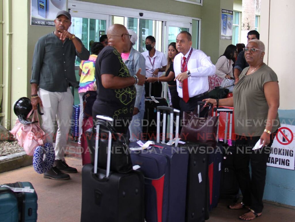 A Caribbean Airlines (CAL) official speaks to passengers after their flights were cancelled at the Piarco International Airport, Piarco on August 20. - Ayanna Kinsale