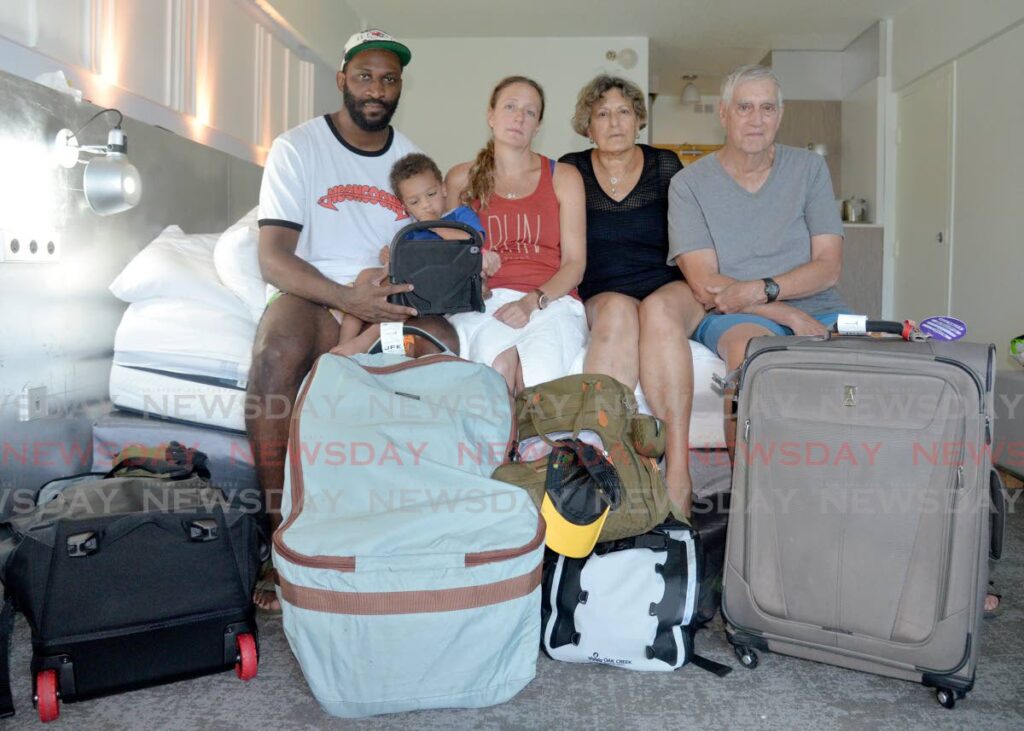 Caribbean Airlines passengers Adrian Crichlow, left, his wife Allison Bondell, their son Ardin Crishlow, Fredi Bondell and Jay Bondell in their hotel room at the Radisson Hotel, Wrightson Road, Port of Spain, on Tuesday. - Anisto Alves