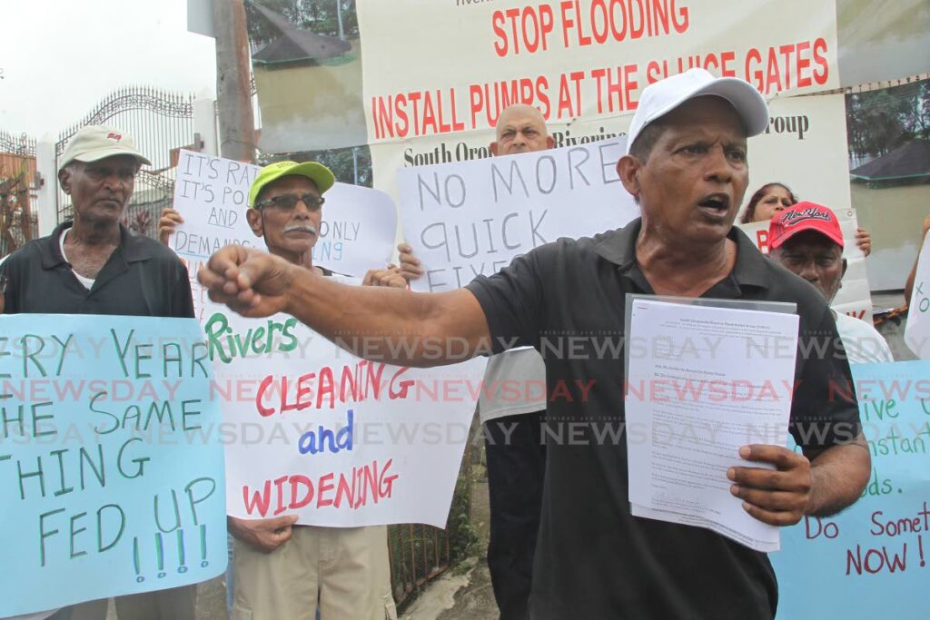 Edward Moodie, head of the South Oropouche Riverine Flood Action Group with residents at a protest. - File photo by Lincoln Holder