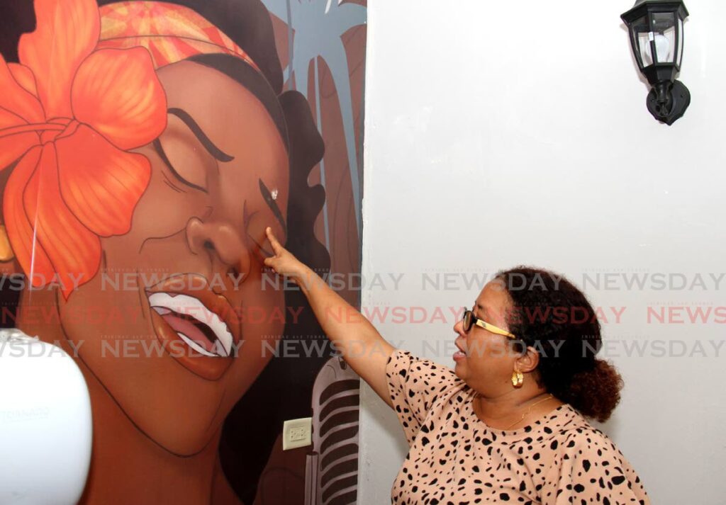 Lopinot Tourism Association CEO Donna Mora points to the damage done to a painting in the washroom at the Lopinot Historical Site in Lopinot Village, Arouca.  - AYANNA KINSALE