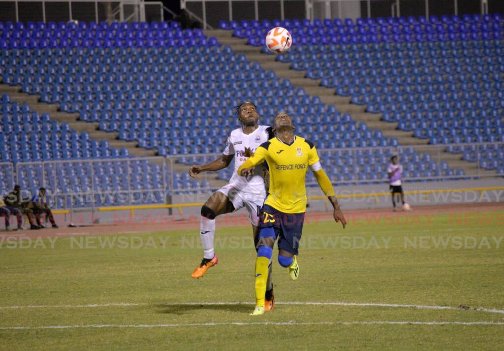 Defence Force FC defender Jamali Garcia (R) and Cavalier FC forward Orlando Russell vie for possession of the ball during the Concacaf Caribbean Cup match, on Thursday, at the Hasely Crawford Stadium, Port of Spain. - Anisto Alves