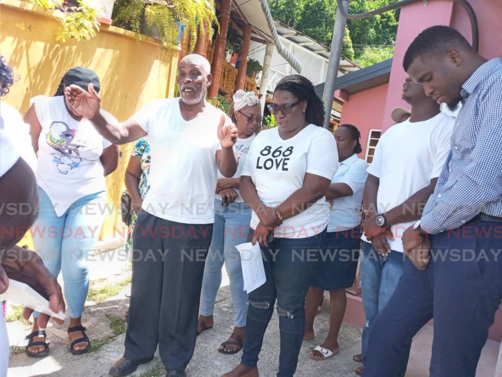 Spiritual Baptist leader Bishop Inniss Edwards, with arms outstretched, leads villagers in prayers after a news conference at the Castara Community Centre on Augsut 24. - Corey Connelly