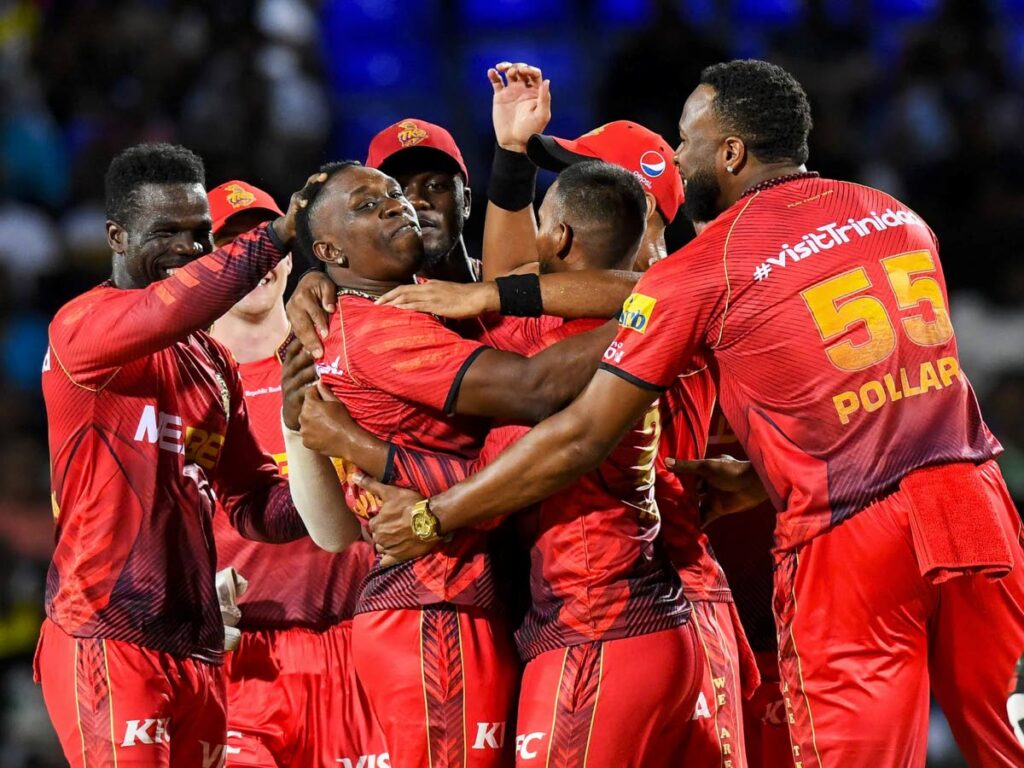 Trinbago Knight Riders players mob Dwayne Bravo, centre, after a wicket against St Kitts and Nevis Patriots on Sunday in the Republic Bank Caribbean Premier League at Warner Park, St Kitts. - Trinbago Knight Riders
