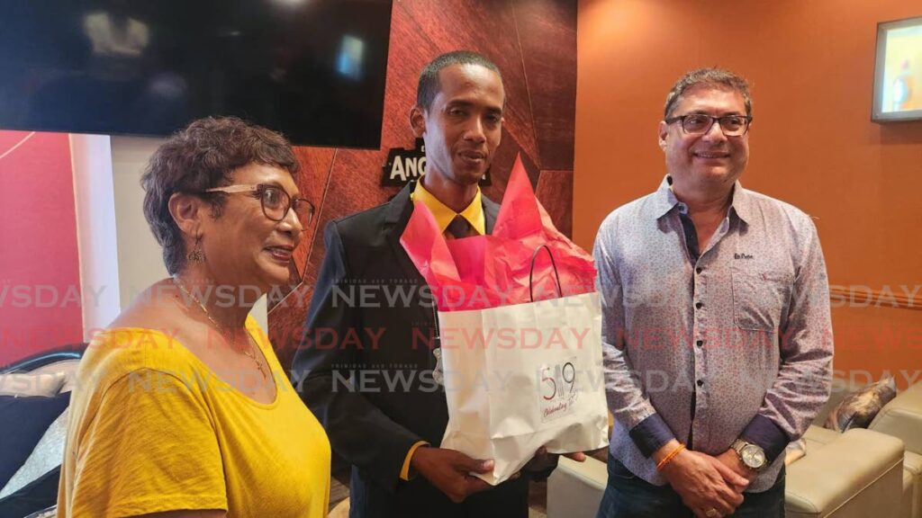 PC Darion Thomas, centre, is presented with an award for gallantry by Greater San Fernando Chamber of Commerce president Kiran Singh and 519 Restaurant investor Suzette Haynes at the restaurant last Wednesday. - Yvonne Webb 