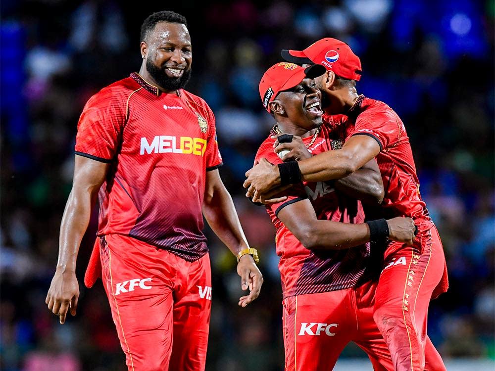 Trinbago Knight Riders captain Kieron Pollard, left, celebrates a wicket with bowler Dwayne Bravo, centre, in a CPL game on Sunday at Warner Park, St Kitts. PHOTO COURTESY TRINBAGO KNIGHT RIDERS - 