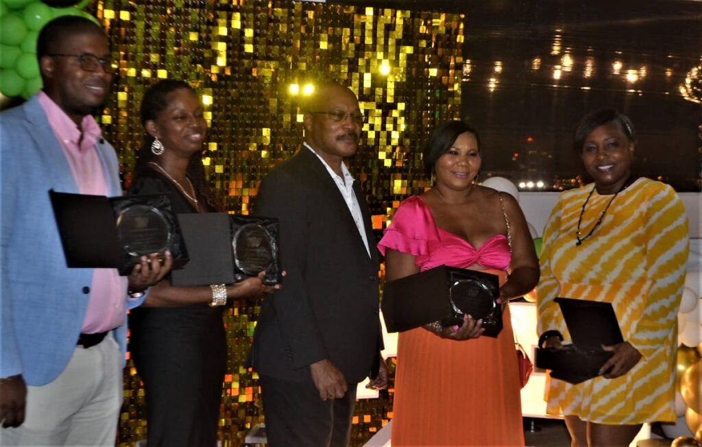 Employees of Worldwide Reinsurance Ltd pose with their awards  and CEO at the company's 25th anniversary celebration: Shaka Franklin, Kwailan Williams, Patrick E Taylor, Janelle La Vende and Turkessa Blades - 