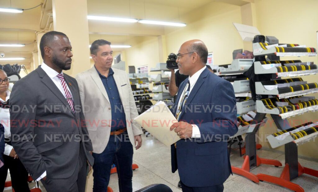TTPost managing director George Alexis, right, speaks with Public Utilities Minister Marvin Gonzales, left, and Diego Martin Central MP Symon De Nobriga at the newly refurbished Diego Martin Post Office, Diego Martin Main Road, on Tuesday.  - Photo by Anisto Alves