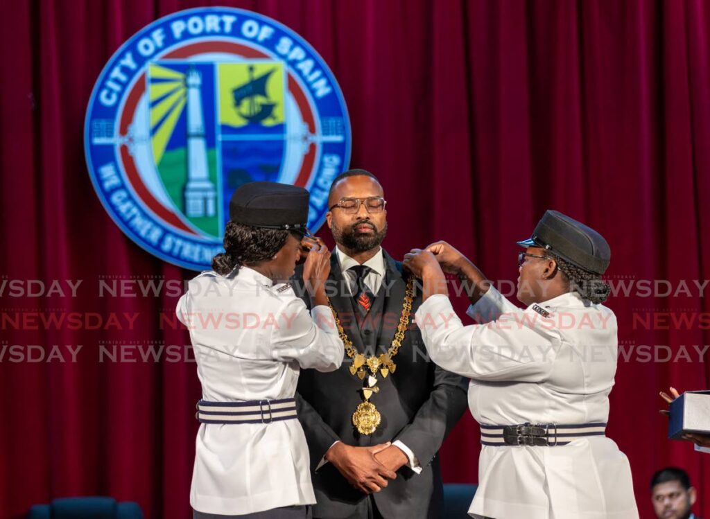 Municipal officers place the mayoral chain on the new POS Mayor Chinua Alleyne at the swearing in ceremony of Aldermen, Mayor and deupty mayor, Murchison Brown Auditorium, City Hall, Port of SPain on August 30 - Photo by Jeff K. Mayers