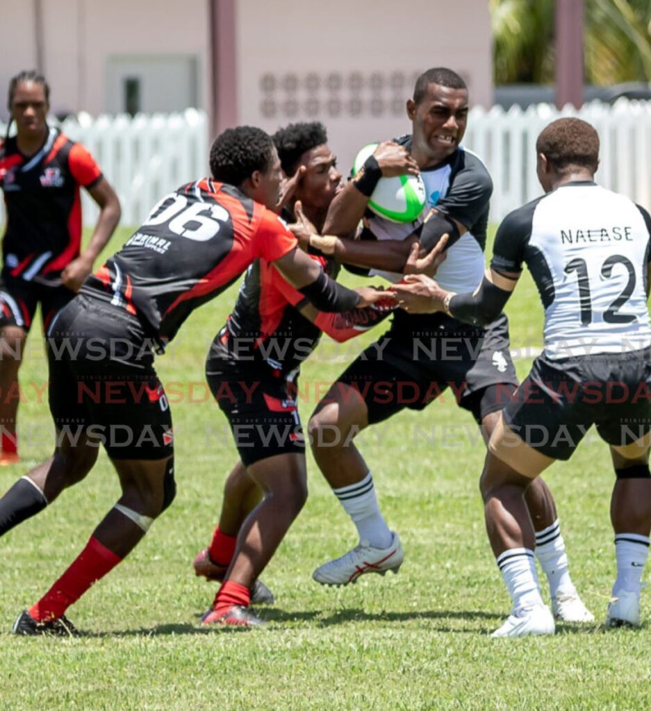 Fiji, right, and TT players battle for the ball in a men's rugby match at the Commonwealth Youth Games, Shaw Park 