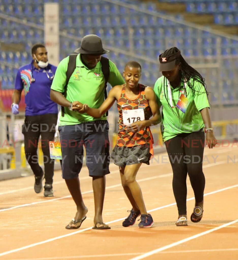 Officials help 100m finals para-athlete cross the finish line after she fell mid-way during the race. Photo by Angelo Marcelle