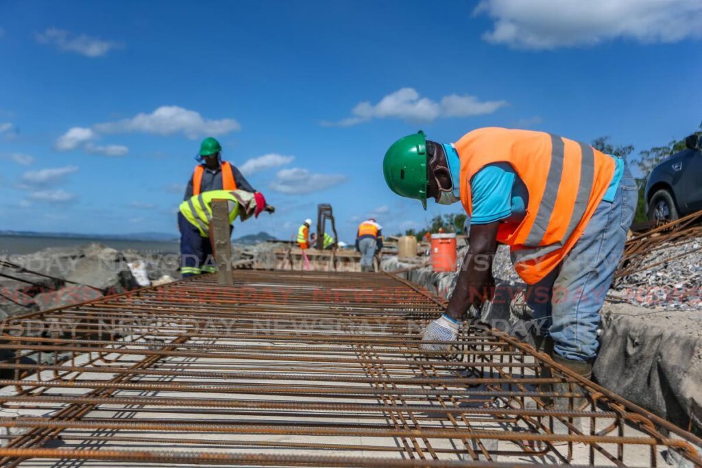 Junior Sammy Ltd workers tying steel which forms the base of the higher seawall to accommodate the elevated roadway which is under construction along the Mosquito Creek, South Trinidad.