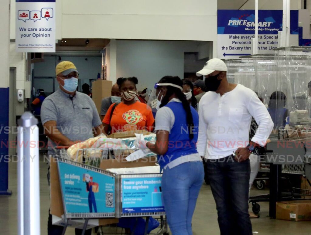 In this file photo, a Pricesmart employee checks a customer's goods at the Port of Spain business.  - 